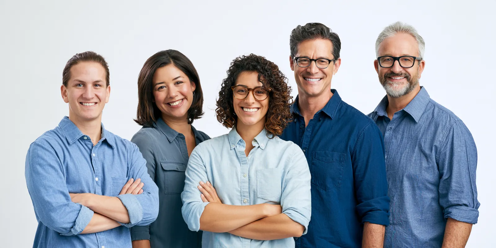 Five smiling coworkers of different ages standing together in a bright studio, the team behind our loan-request service