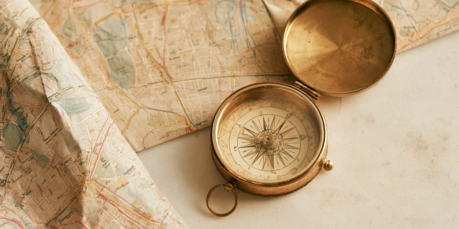 Unfolded city street map with a brass compass on a light table